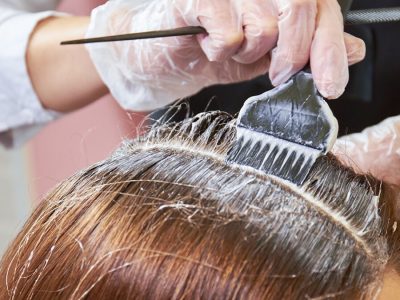 Hair dying close up. Brush applying hair color.